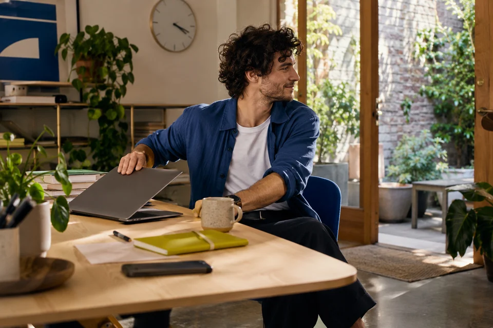 A colleague closes his laptop at the end of a working window